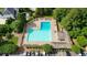 A large swimming pool area with lounge chairs, umbrellas, and mature trees at 6705 Brookline Ct, Cumming, GA 30040