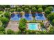 An aerial view of a pool and tennis courts surrounded by lush greenery at 6705 Brookline Ct, Cumming, GA 30040