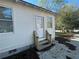 Exterior of home with stairs leading up to a door, surrounded by a spacious yard and trees at 31 N Broad N St, Porterdale, GA 30014
