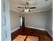 Bright bedroom featuring hardwood floors, ceiling fan, and neutral paint at 31 N Broad N St, Porterdale, GA 30014