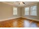 Bright bedroom features hardwood floors, neutral paint, and large windows at 31 N Broad N St, Porterdale, GA 30014