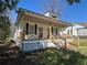 Charming home featuring a covered front porch with black shutters and landscaped yard at 31 N Broad N St, Porterdale, GA 30014