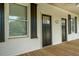 Spacious covered front porch showcasing a double entry, shutters, and wood flooring at 31 N Broad N St, Porterdale, GA 30014