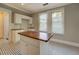 Kitchen island with butcher block countertop and charming checkerboard floors at 31 N Broad N St, Porterdale, GA 30014