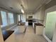 Bright kitchen with a kitchen island, white cabinetry, stainless steel appliances, and black and white tile flooring at 31 N Broad N St, Porterdale, GA 30014