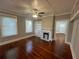 Bright living room with refinished floors, fireplace, built-in shelving, and many windows at 31 N Broad N St, Porterdale, GA 30014