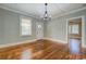 Spacious living room with original hardwood floors, modern light fixture, and white door with glass panel at 31 N Broad N St, Porterdale, GA 30014