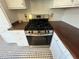 Close-up of a stainless steel stove with wooden countertops and white cabinets at 31 N Broad N St, Porterdale, GA 30014