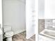 Bathroom featuring a toilet, built-in shelves, and a view of the soaking tub at 727 Copper Trace Way, Woodstock, GA 30189