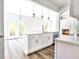 Modern kitchen with white cabinets, stainless steel appliances, and a kitchen island at 727 Copper Trace Way, Woodstock, GA 30189