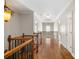 Upstairs hallway with hardwood floors and elegant light fixture at 255 Kendemere Pointe, Roswell, GA 30075