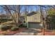 Exterior view of home with attached garage, lush landscaping and mulch at 355 N Peak Dr, Alpharetta, GA 30022