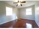 This bedroom features hardwood floors, two windows, a ceiling fan, and light gray walls at 2020 Kenwood Se Pl, Smyrna, GA 30082