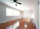 Bright living room featuring hardwood floors, large windows, a ceiling fan, and neutral paint, awaiting personal touches at 2020 Kenwood Se Pl, Smyrna, GA 30082