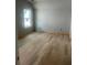 Bedroom features hardwood flooring, neutral gray walls, and bright natural light coming in from the window at 108 Cottage Gate Ln, Roswell, GA 30076