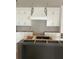 Kitchen is getting new cabinets installed, featuring a gray kitchen island and white cabinets at 108 Cottage Gate Ln, Roswell, GA 30076