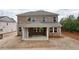 Rear exterior view of a two-story brick home showcasing a covered patio and expansive yard at 5133 Greenard Watson Lane, Buford, GA 30518
