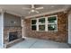 This covered patio features a brick fireplace and ceiling fan, perfect for outdoor relaxation at 5133 Greenard Watson Lane, Buford, GA 30518