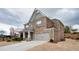 Two-story brick home featuring an attached garage and well-manicured landscaping at 5133 Greenard Watson Lane, Buford, GA 30518