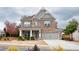 Beautiful two-story brick home featuring a covered porch and attached two-car garage at 5133 Greenard Watson Lane, Buford, GA 30518