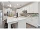 Bright kitchen with white cabinets, stainless steel appliances, island and tiled backsplash at 5133 Greenard Watson Lane, Buford, GA 30518