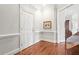 Bright hallway with hardwood floors, white wainscoting, and an interior door at 3657 Peachtree Ne Rd # 2C, Atlanta, GA 30319