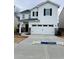 Two-story white house with a two-car garage and landscaped yard at 7520 Saffron Ave, Covington, GA 30014