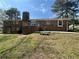 Spacious backyard featuring a raised deck, brick exterior, mature trees and established lawn at 6595 Malvin Dr, Austell, GA 30168