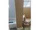 Bathroom with a toilet, tub and window allowing natural light to brighten the room at 6595 Malvin Dr, Austell, GA 30168