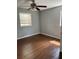 Bedroom features hardwood floors, neutral walls, a ceiling fan, and natural light from a window at 6595 Malvin Dr, Austell, GA 30168