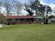 Charming brick home with a well-maintained lawn and mature trees providing shade at 6595 Malvin Dr, Austell, GA 30168