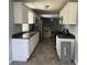 Galley kitchen with white cabinets, granite countertops, tile flooring, and stainless steel appliances at 6595 Malvin Dr, Austell, GA 30168