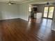 Open concept living space with hardwood floors, fan, and adjacent kitchen with breakfast bar at 6595 Malvin Dr, Austell, GA 30168