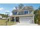 Charming two-story home featuring a front porch, attached garage, and a well-manicured lawn at 2599 Windsor Knoll Dr, Dacula, GA 30019