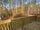 A wooden porch overlooks a peaceful backyard filled with beautiful autumn trees at 60 Hammock Dr, Covington, GA 30016