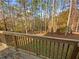 A wooden porch provides a nature view of the backyard full of beautiful autumn trees at 60 Hammock Dr, Covington, GA 30016