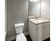 Bathroom with granite countertop, white vanity, and toilet at 60 Hammock Dr, Covington, GA 30016