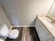 Cozy bathroom with granite countertop, white vanity, toilet, and wood-look flooring at 60 Hammock Dr, Covington, GA 30016