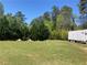 Extensive grassy lot featuring storage container with mature trees at 1565 Dr Bramblett Rd, Cumming, GA 30028