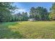 Expansive grassy yard with trees, ideal for outdoor activities or expansion of the home at 1565 Dr Bramblett Rd, Cumming, GA 30028