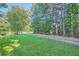Large, well-maintained lawn bordered by mature trees, providing a serene and private setting at 1565 Dr Bramblett Rd, Cumming, GA 30028