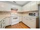 Kitchen features white cabinets, a range, and a microwave at 1115 Cannongate Sw Xing, Marietta, GA 30064