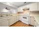 Bright kitchen features white cabinets and an opening to a separate living space at 1115 Cannongate Sw Xing, Marietta, GA 30064