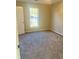 Cozy bedroom with neutral walls, carpet, and a window view to the backyard at 1255 Silverstone Trl, Jonesboro, GA 30238