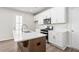 Bright kitchen featuring white cabinets, stainless steel appliances, and an island with quartz countertops at 40 Spirea Way, Auburn, GA 30011