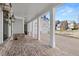 Front porch with brick flooring, white columns, and a view of the driveway and garage at 1005 Coleman Place Dr, Roswell, GA 30075