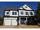 Two-story home with gray siding, dark shutters, and a three-car garage at 1010 Coleman Place Dr, Roswell, GA 30075