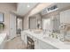 Bright bathroom featuring double sinks, white cabinetry, framed mirrors and a skylight at 992 Bridgegate Ne Dr, Marietta, GA 30068