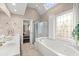 Bright bathroom featuring a soaking tub, walk-in shower, double sinks, and a skylight at 992 Bridgegate Ne Dr, Marietta, GA 30068