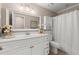 Neutral-toned bathroom featuring white vanity, framed mirror and a bathtub with shower at 992 Bridgegate Ne Dr, Marietta, GA 30068